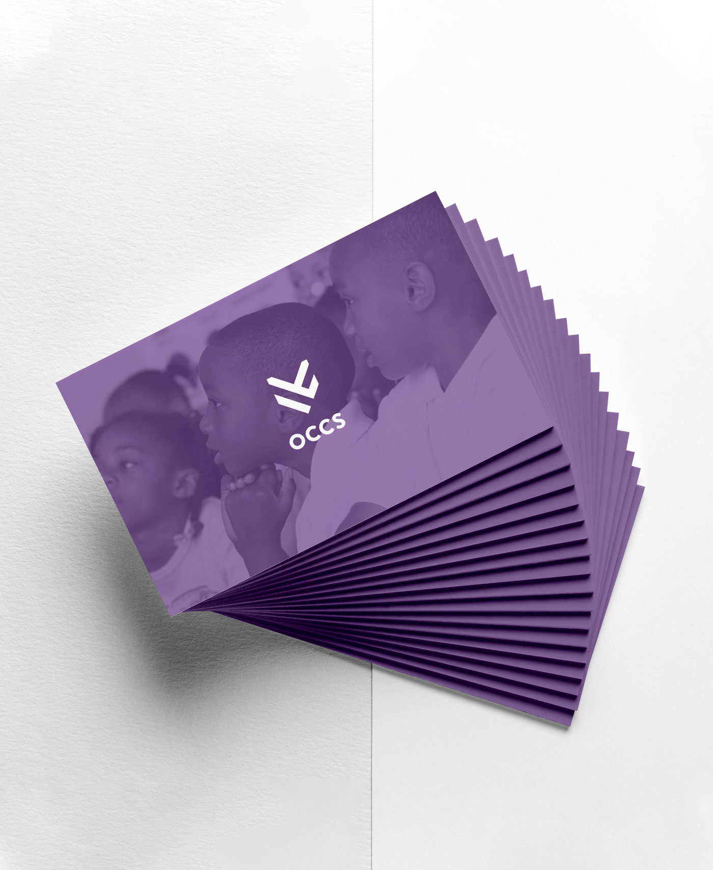 OCCS branded business cards spread out and rotated over light tabletop