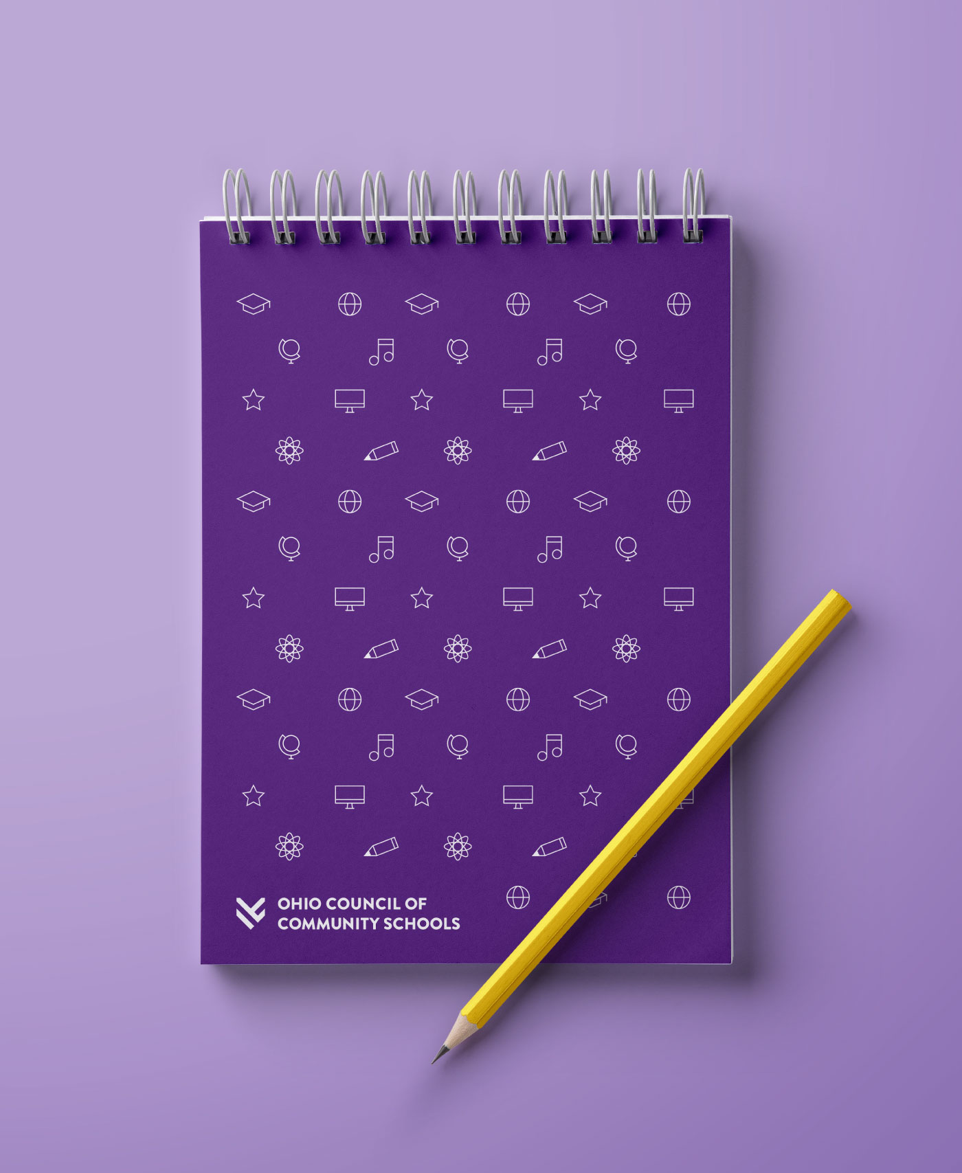OCCS branded notebook with pencil over purple tabletop