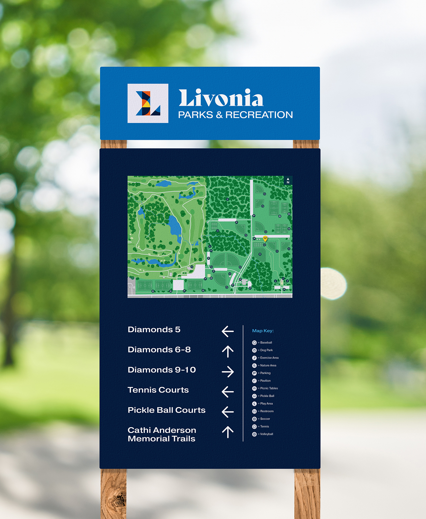 Park signage set up near a parking lot that displays a map and legend
